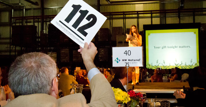 Gary Bauer, director of government and community affairs, NW Natural, raises paddle during Special Appeal, led by auctioneer Johnna Wells, at “Home Grown,” Oregon Food Bank’s annual gala fundraiser, Oct. 15, 2011.