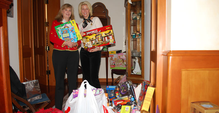 Jill Inskeep and Susie Porter pose with the Toy and Joy gifts brought by guests