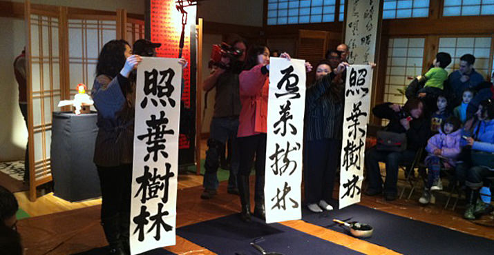 Calligraphy students hold up their calligraphy characters.