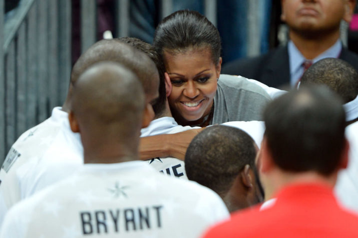 First Lady Michelle Obama (C) of the United States hugs Kevin Love after their Men's Basketball game between the United States and France on Day 2 of the London 2012 Olympic Games at the