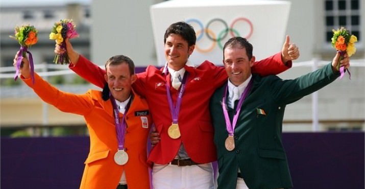 Steve Guerdat of Switzerland celebrates on the podium after winning the Gold medal, Gerco Schroder of Netherlands (L) the Silver medal and Cian O'Connor of Ireland (R) the Bronze medal in the Individual Jumping Equestrian on Day 12 of the London 2012 Olympic Games.