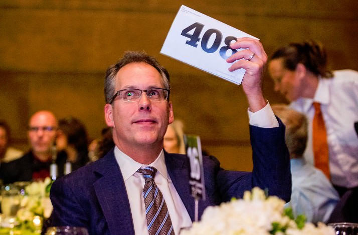 Charlie Swindells, representing the Ann and Bill Swindells Charitable Trust, raises his paddle during the live appeal. The Ann and Bill Swindells Charitable Trust generously offered a $100,000 matching gift to the DoveLewis building fund over the next year. 