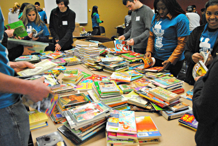 College students begin sorting through gently used children's books. Throughout the day, 700 students organized, cleaned, and helped distribute 40,000 books to low-income homes, libraries, and schools in Portland.
