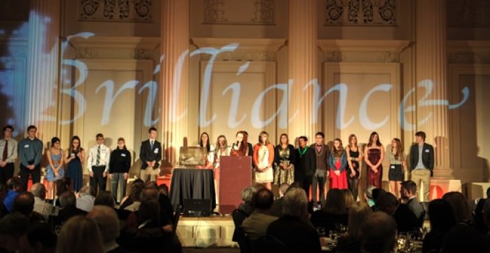 Edison student volunteers gathered onstage to support the Brilliance Benefit student speaker, who shared her story and encouraged guests to donate to financial aid at Thomas Edison High School.
