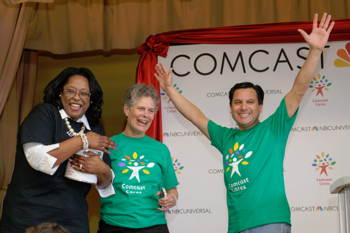 LaShawn Lee, Faubion School principal; Carole Smith, Portland Public Schools superintendent; and Rodrigo Lopez, Comcast regional vice president, burst with excitement for Faubion's day of restoration on Comcast Cares Day. Photo by Andie Petkus.