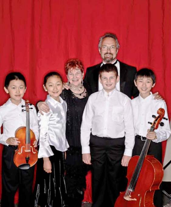 Oregon Symphony Music Director Carlos Kalmar with Portland Youth Philharmonic’s Young String Ensemble and their conductor, Carol Sindell.