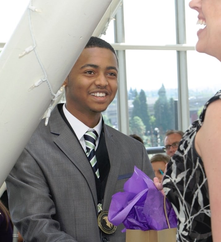 Melaku Arega receives iPad mini in addition to a $1,000 Leaders and Achievers scholarship. Photo by Andie Petkus.