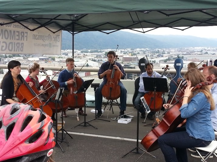 Bicyclists stopped on the top deck of the Fremont bridge to listen to the cellists. 