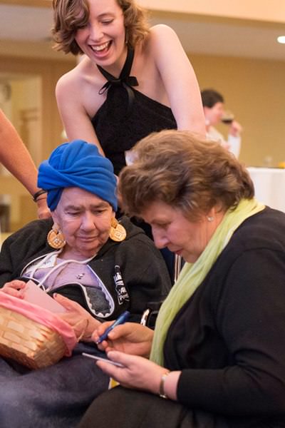 L'Arche Portland resident Marilyn Petruzzelli and Jessica Weisensee sell a raffle ticket to Dorothy Coughlin, L'Arche Portland founder and Director of the Office for People with Disabilities at the Archdiocese of Portland