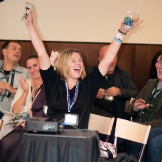 Gretchen Gallagher throws up her hands in excitement for her win in the live auction!