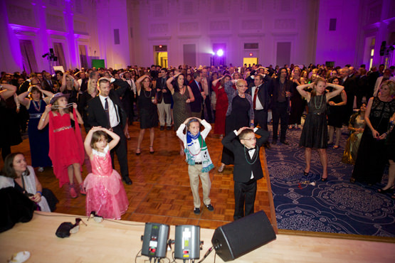 Wish Ball guests - joined by several wish kids - take part in a game of Heads or Tails. The winner received a pair of first class Alaska Airlines tickets.
