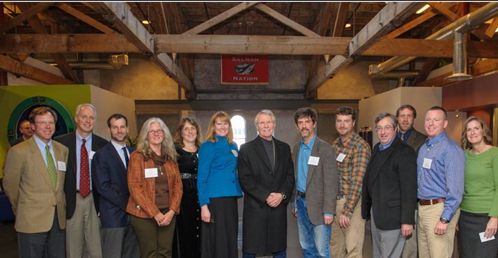 Governor Kitzhaber stands with Wild Salmon Center and their partners in protecting wild salmon strongholds. (left to right) Guido Rahr (Wild Salmon Center), Tom Byler (Oregon Watershed Enhancement Board), Joe Furia (Freshwater Trust), Krystyna Wolniakowski (National Fish and Wildlife Foundation), Maggie Peyton (Upper Nehalem Watershed Council), Allison Hensey (Oregon Environmental Council), Governor John Kitzhaber, Steve Wise (Sandy River Basin Watershed Council), Scott Turo (Confederated Tribes of Warm Springs), Russell Hoeflich (The Nature Conservancy), Mark Trenholm (Wild Salmon Center), Eric Riley (Partnership for the Umpqua Rivers), and Cara Rose (National Fish and Wildlife Foundation).