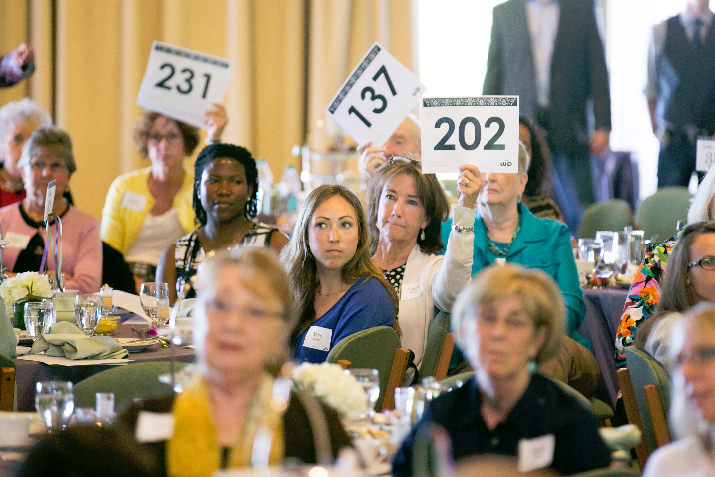 Bidders raise their paddles at Warner Pacific's April 12 President's Tea 