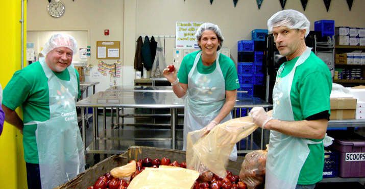 Comcast employees Gary Yates and Kathy McGowan, and Hands On Greater Portland volunteer Mark Vanderyacht, bag apples at the Oregon Food Bank volunteer action center. Photo by Theresa Smith.