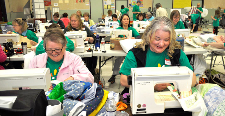 Community volunteer Pat and Comcast human resources manager Gina Fox sew blankets for children in need at Binky Patrol.Photo by Tracy Preston.