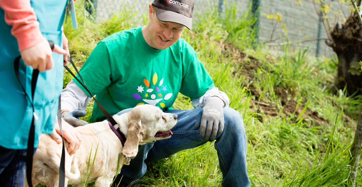 Comcast construction technician Brent Christiansen takes a break from working on the Oregon Humane Society's walk path to greet Buffy the dog. Photo by Courtney Zerezif.