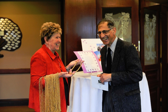 Event volunteer Diane Millemann does her best to convince guest Ron George that buying beads will add some fun to his evening.