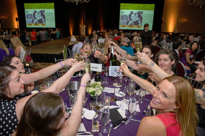 Urban Waxx staff members toast the cause at their sponsor table