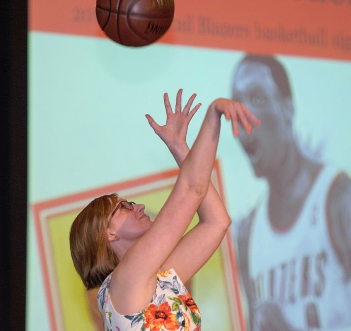 Bradley Angle economic empowerment coordinator Cassie Russell shows off her form and a basketball signed by the 2013-14 Trail Blazers. 