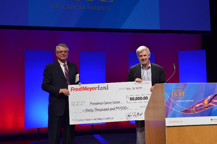 Walter J. Urba, M.D., Ph.D., oncologist and director, Robert W. Franz Cancer Research Center in the Earle A. Chiles Research Institute, Providence Cancer Center, accepts a $60 thousand check from Lynn Gust, president, Fred Meyer Stores. The donation is the result of contributions from Fred Meyer employees and customers.   