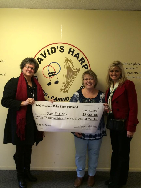 100 Women Who Care Portland of Founder, Annemie Williams, presenting a donation to David's Harp representatives, Mary Kautzer, Program Manager and Becky Hubbard, Board Chair.