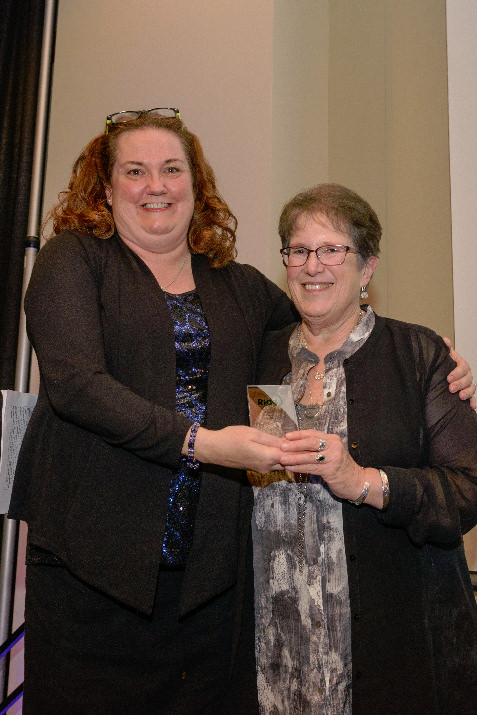 Elaine Wells receives an award from Allison Stoll, honoring her 25 years of dedicated, passionate service to Ride Connection. 