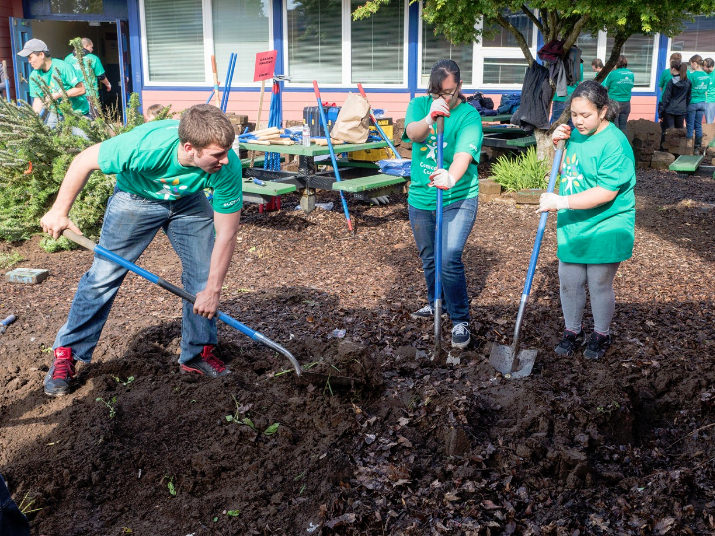 Comcast Cares Day volunteers Leo Harbo, Tiana Sablan, and Louanne Mendiola garden at Glenfair Elementary. Photo by Aaron Hockley.