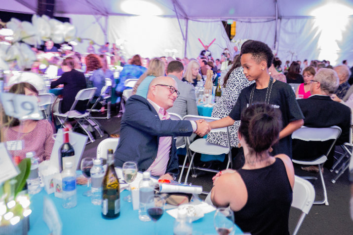 A Friends of the Children program youth shakes the hand of donor Shane Wall after he wins a live auction package. 