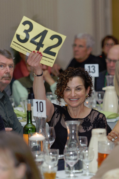 Sona K. Andrews, Provost and Vice President for Academic Affairs at Portland State University, raises her bid card high at the Human Solutions auction.