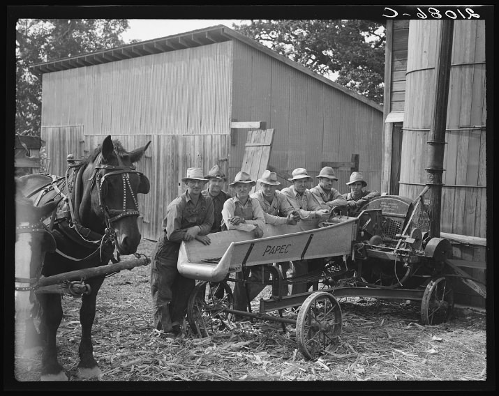 Seven of the eight farmers shown with their cooperatively owned ensilage cutter on the Miller farm, where they are working filling the silo. Yamhill County, Oregon. General caption number 58