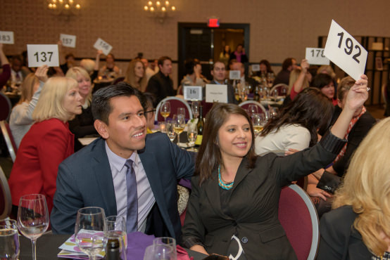 | Guest speaker Rolando Cruz and wife Araceli give generously during the special appeal, as fellow supporters hold their bid cards high. 