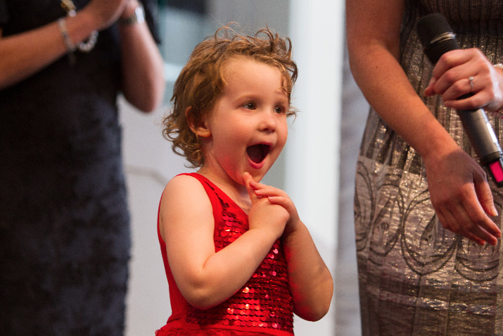 Wish kid Ellerie, 3, gasps in excitement as she takes center stage during the Wish Ball’s VIP dinner. 