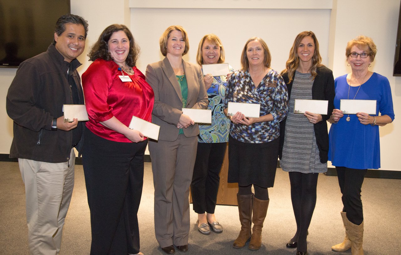 Charity recipients pose with checks received from BULL Session: Ray Baluyut, Randall Children's Hospital; Kay Ekeya, Shriners Hospital for Children®-Portland; Anjie Vannoy, March of Dimes; Cheryl Sheppard, Gales Creek Camp Foundation; Jodi Lippert, Albertina Kerr's Children's Developmental Health Services; Stephanie Montgomery, Swindells Resource Center of Providence Child Center; and Sandy Getman, Wheel to Walk.