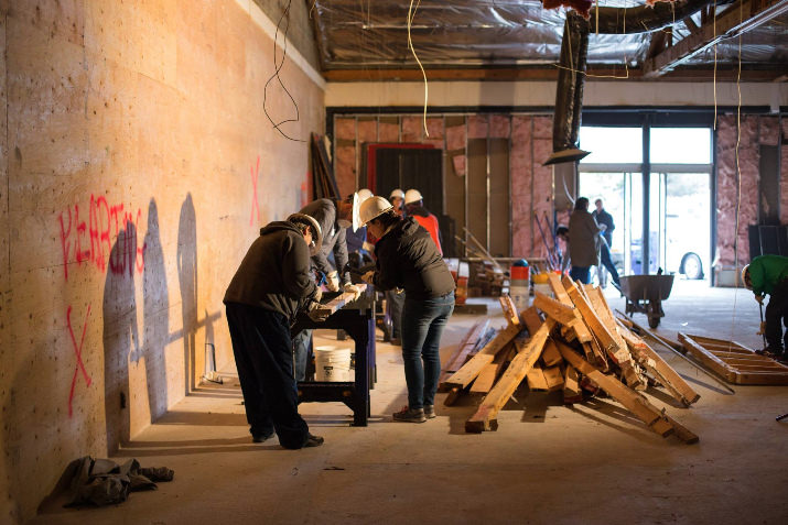 Volunteers swinging sledge hammers and cleaning up the grounds to help transform Living Cully Plaza into a space for the community.