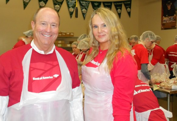 Bank of America’s Oregon and southwest Washington market president Roger Hinshaw and Monique Barton, senior vice president of corporate social responsibility at Bank of America, help repackage food at Oregon Food Bank’s fifth annual day of service sponsored by Bank of America.
