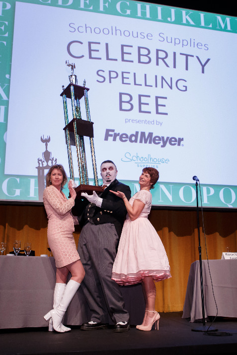 Hosts Pat Janowski and Mary McDonald-Lewis congratulate spelling champion Baron Von Goolo at the 2016 Schoolhouse Supplies Celebrity Spelling Bee, presented by Fred Meyer.