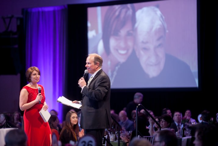 Valerie Hurst, emcee, and Graham Crow, auctioneer, share a moment reflecting on Valerie's father who is living with ALS in Massachusetts.