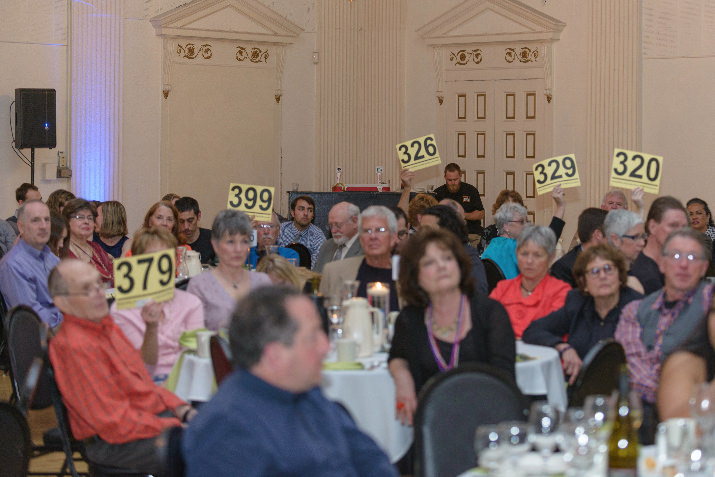 Guests raise their bid cards high during the live auction. 