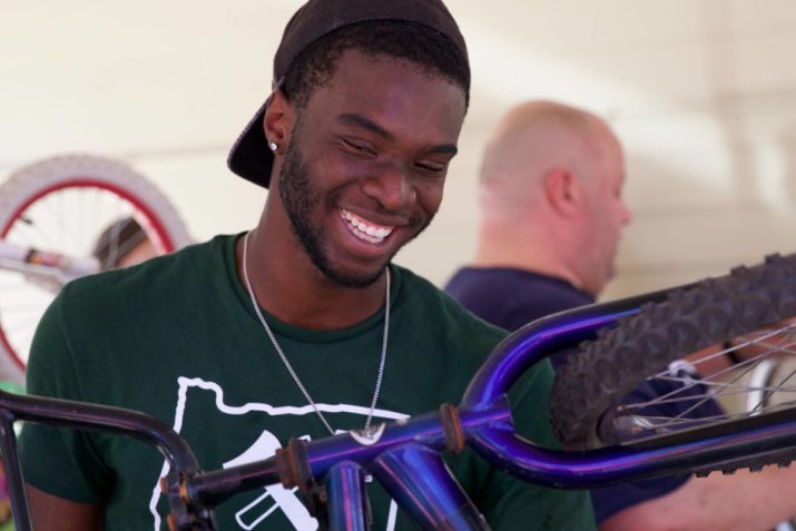 June 6, 2016; Portland, OR, USA; T2 defender Rennico Clarke joins volunteers from the community in fixing bicycles at the Community Cycling Center in NE Portland. Photo: Eric Cech-Portland Timbers — at Community Cycling Center.