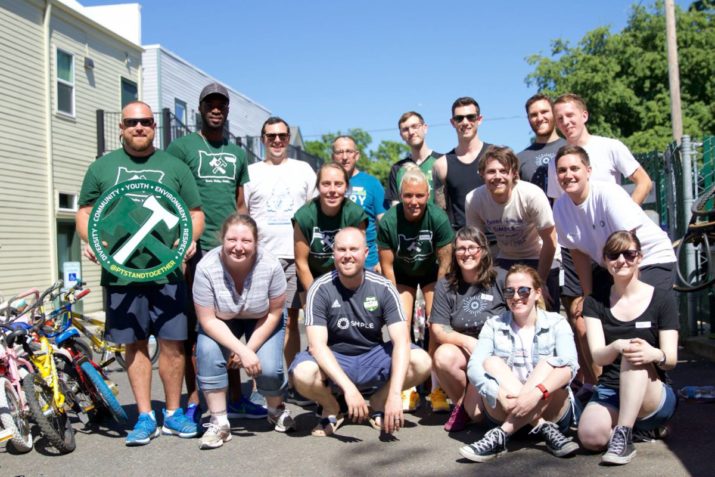 June 6, 2016; Portland, OR, USA; Thorns players Mana Shim, Mckenzie Berryhill and Celeste Boureille work with Timbers 2 player Rennico Clarke to fix bicycles at the Community Cycling Center in NE Portland. Photo: Eric Cech-Portland Timbers — with Community Cycling Center at Community Cycling Center.