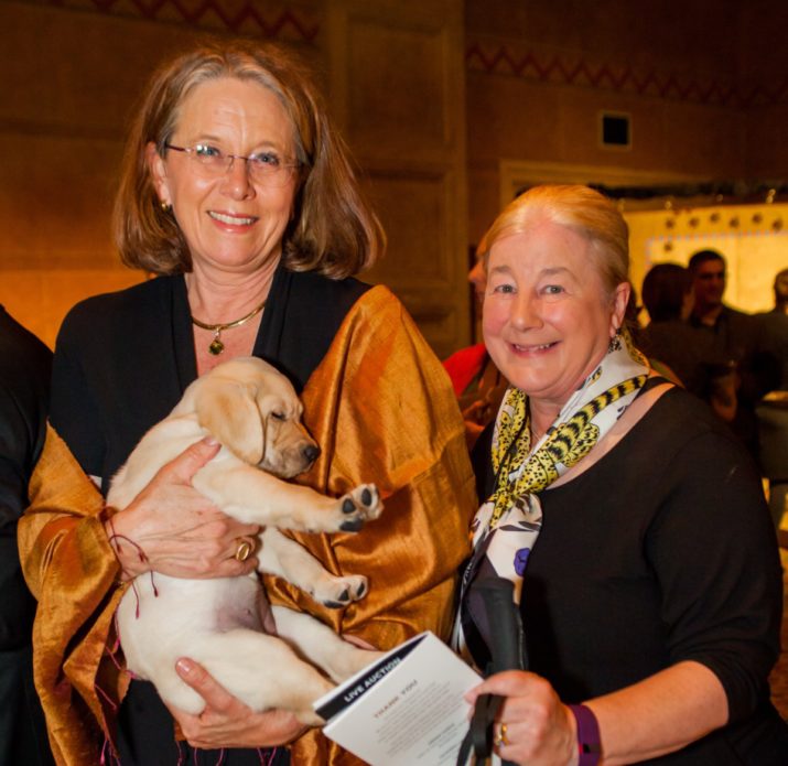 GDB Board Member Sigrid Button and long-time GDB supporter Dr. Laurie Christensen, with a sleepy guide dog puppy.