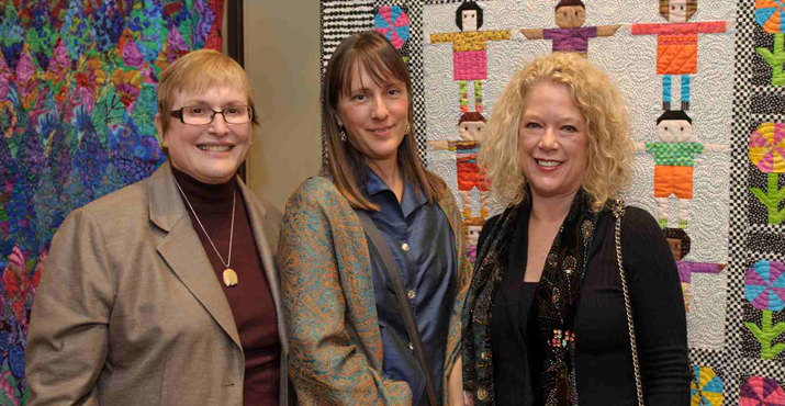 Carla Harris R.N. CAO Randall Children's hospital at Legacy Emanuel left, with Lisa DeHarrport and LuAnn Rukke who created the Garden of Peace quilt in the background. Carla Harris purchased this quilt to hang in the new Randall Children's Hospital.