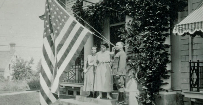 David T. Mason and Family stand on their porch by a flag on the 4th of July 1922. The home is at 509 (Later 1525) SW Myrtle.