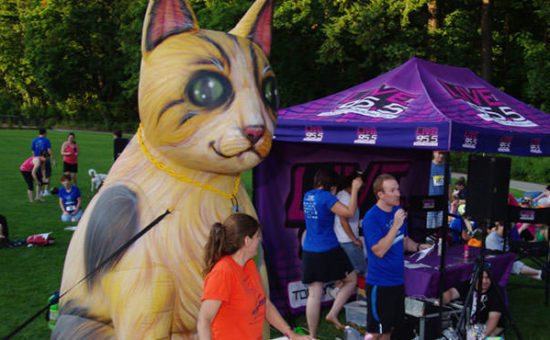 Closing ceremonies included raffle prizes and awards for fastest finishers – all done in front of the big cat (in orange – Kathy Covey, Race Director; in blue – Aaron Asmus, CAT Executive Director)