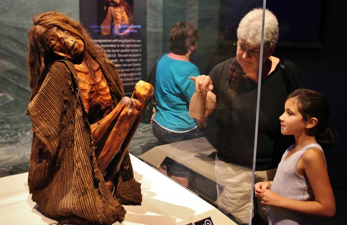 The Tattooed Woman – This young woman with long, black hair was naturally mummified in the warm desert air, seated in the burial position typical in Chile before 1400 A.D. She was wrapped in fabric after her death, the impression of which is still visible on her chin and cheeks. She has unusual tattoos; an oval with a dot inside on both breasts and beneath the left corner of her mouth. Little is known about the meaning of these mysterious tattoos. (Photo credit: Darryl Moran)