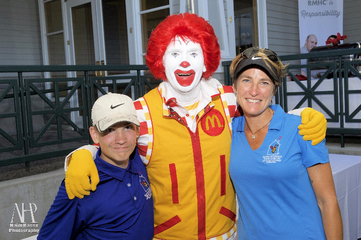 Wade Chosvig, a former Ronald McDonald House guest, poses with CEO Jessica Jarratt Miller and Ronald McDonald. Wade spent the day on the links showing off his incredible golf skills and helped announce this year's tournament winners.